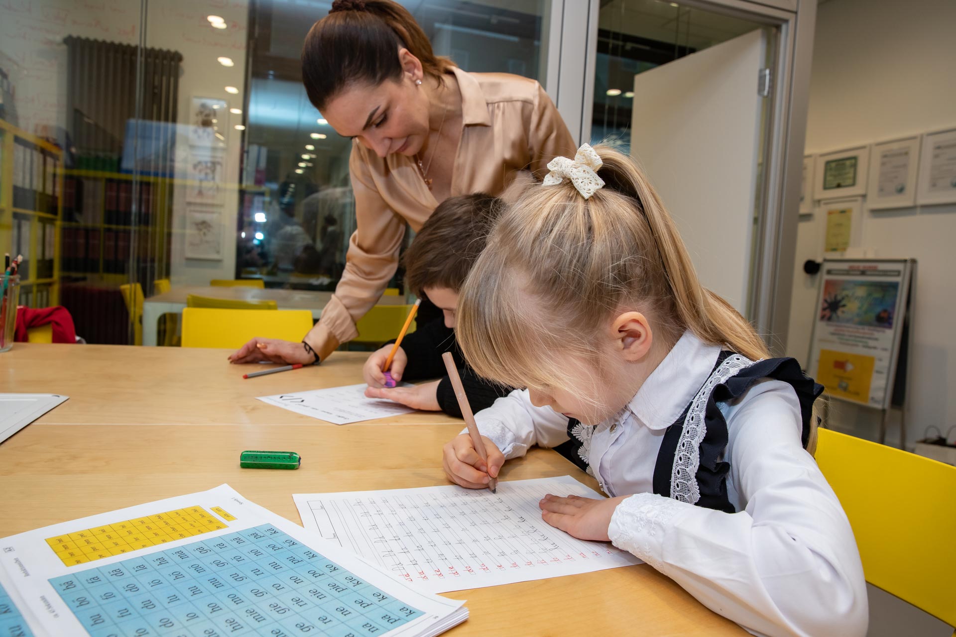 Hermina arbeitet gemeinsam mit zwei Kindern am Tisch